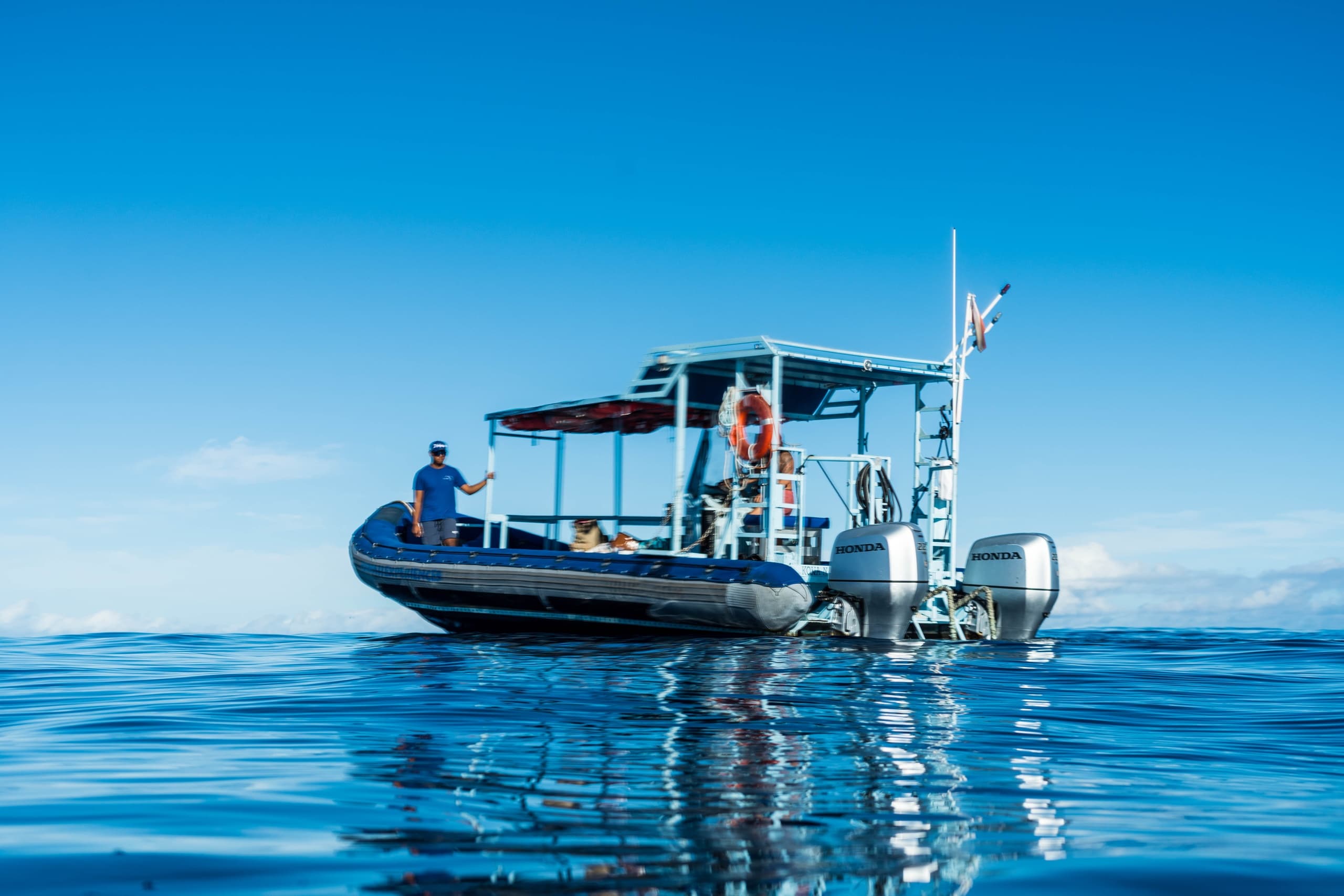 Small excursion boat floating on calm blue ocean waters