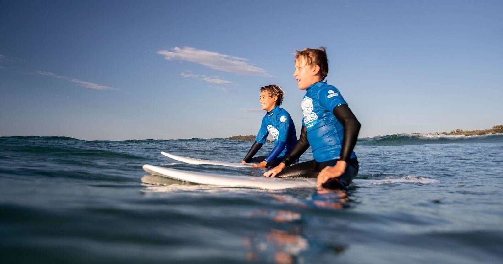 Surfers sitting on boards in the ocean waiting for waves