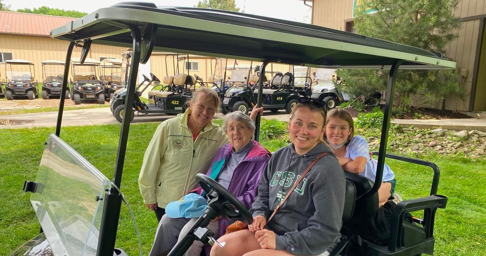 Group enjoying a golf cart ride on grassy Erie Island trails