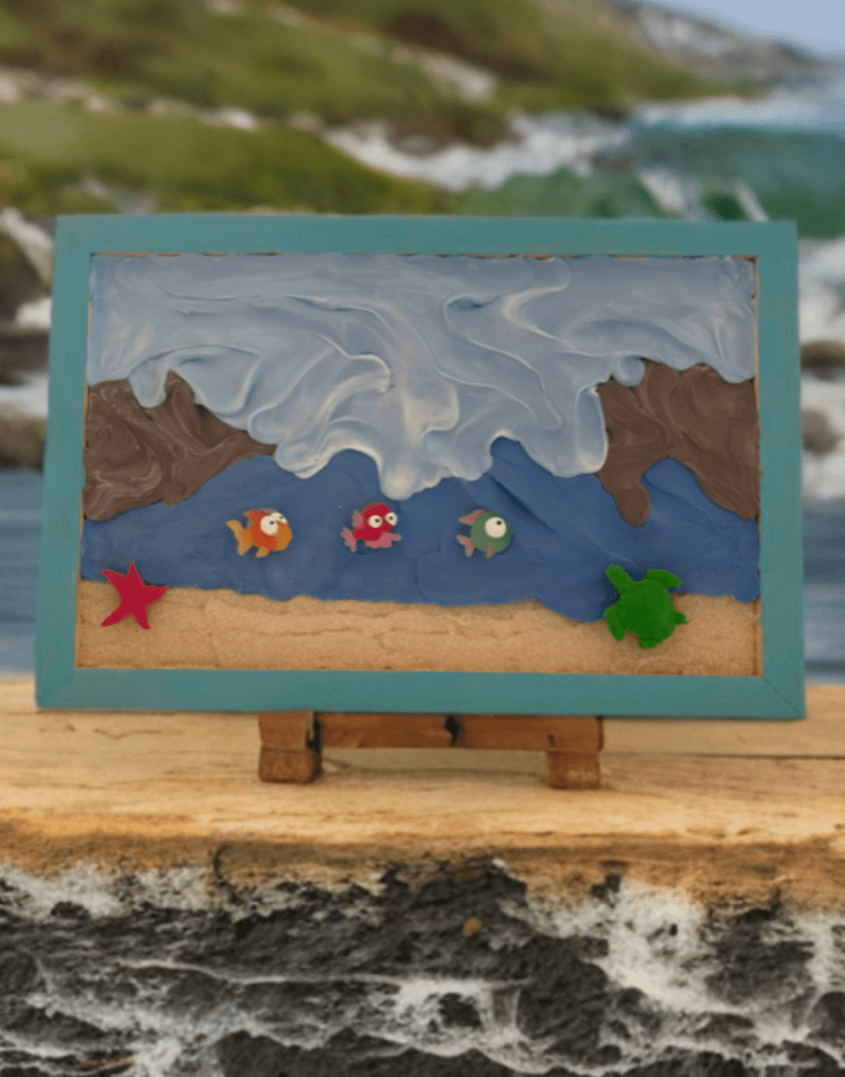 Beach painting on easel by rocky shore with ocean waves