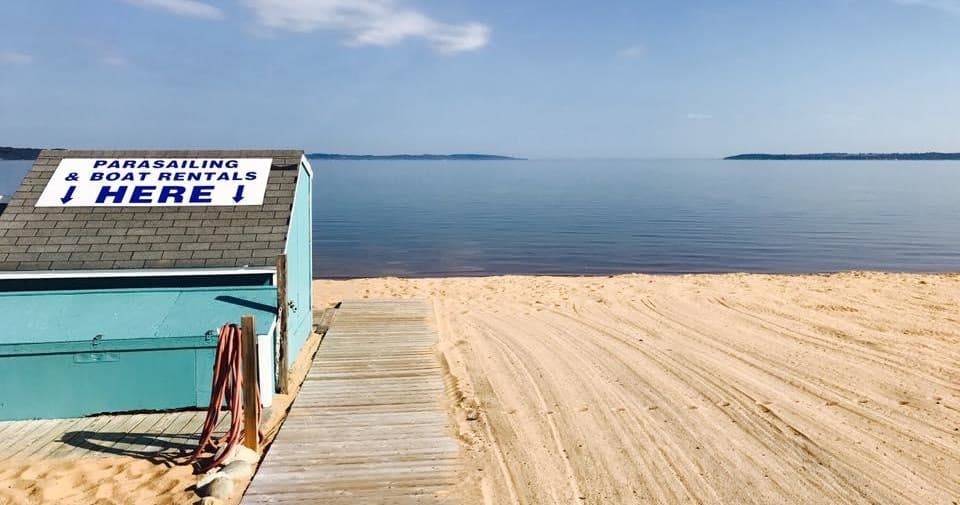 Sandy beach and parasail rental shack on calm coastal shoreline