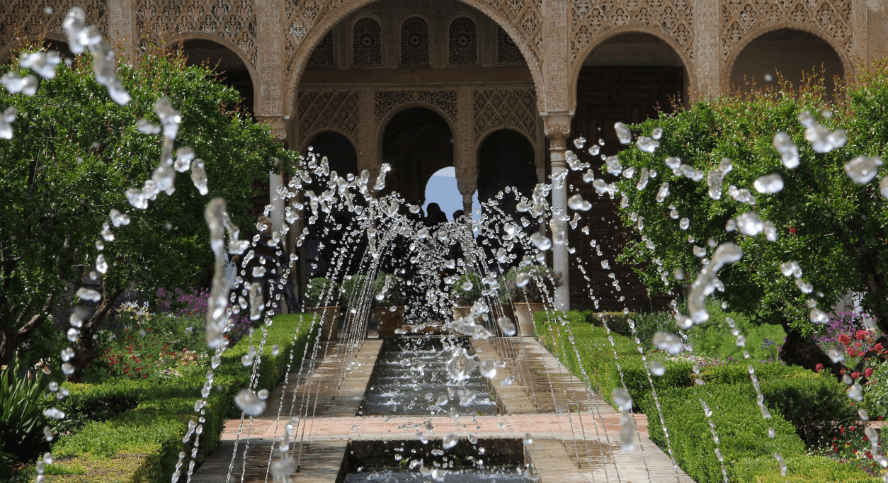 Ornamental fountain jets in Alhambra garden courtyard, scenic stroll