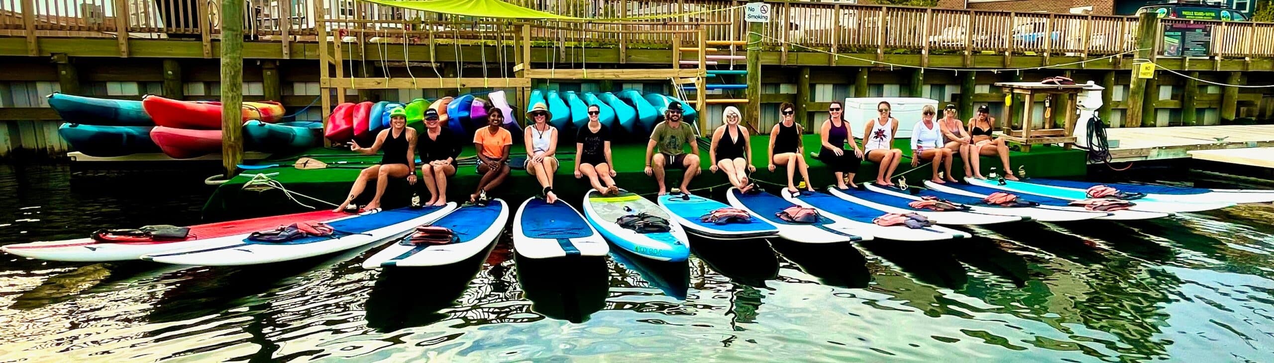Line of paddleboards docked at a marina, ready for rentals