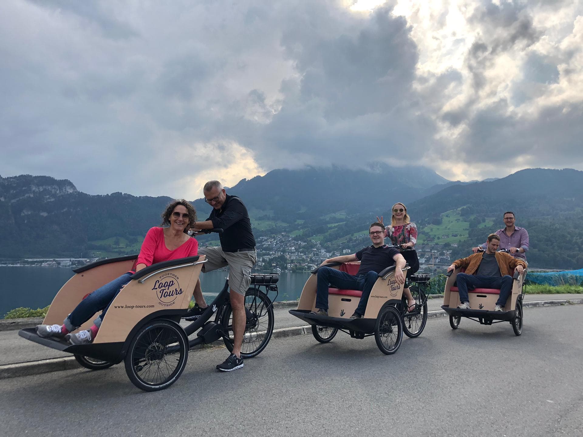 Rickshaw bike tours on mountain road with lake views