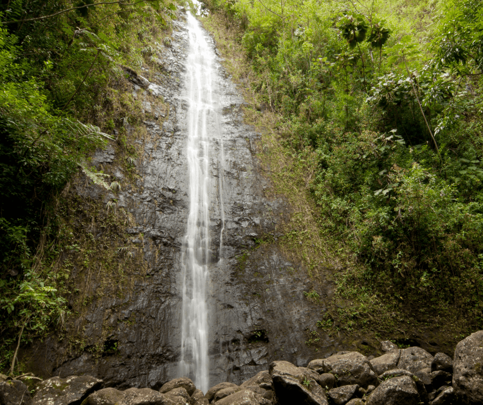 Lush tropical waterfall cascading through green Hawaiian valley