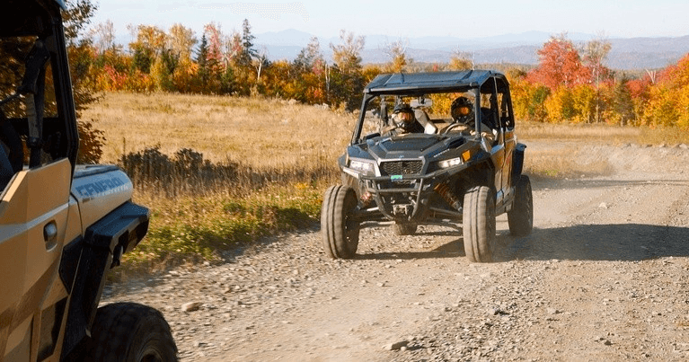 UTV riding on dirt road with fall foliage and open vistas