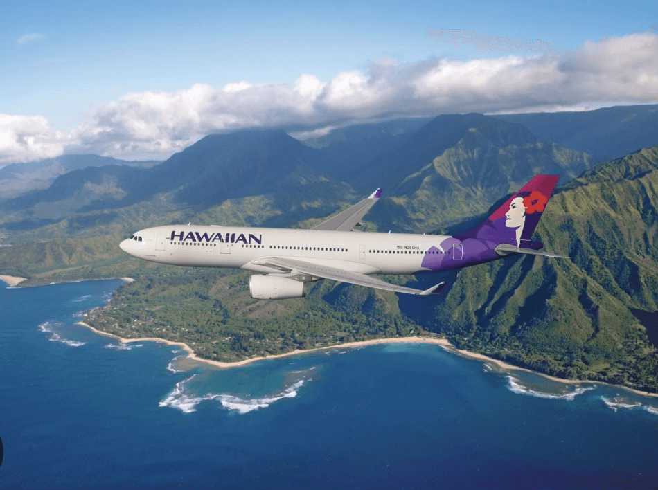 Hawaiian Airlines plane flying over rugged tropical coastline