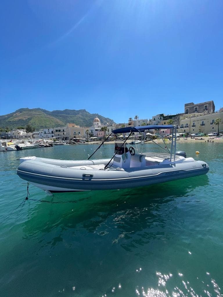 RIB boat tour cruising near Ischia bay under clear sky