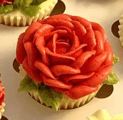 Red rose buttercream cupcake close-up on neutral background