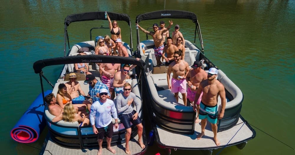 Crowd on pontoon boats enjoying a sunny lake party experience