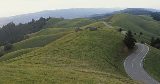 Winding road across green hills and ridgeline landscape