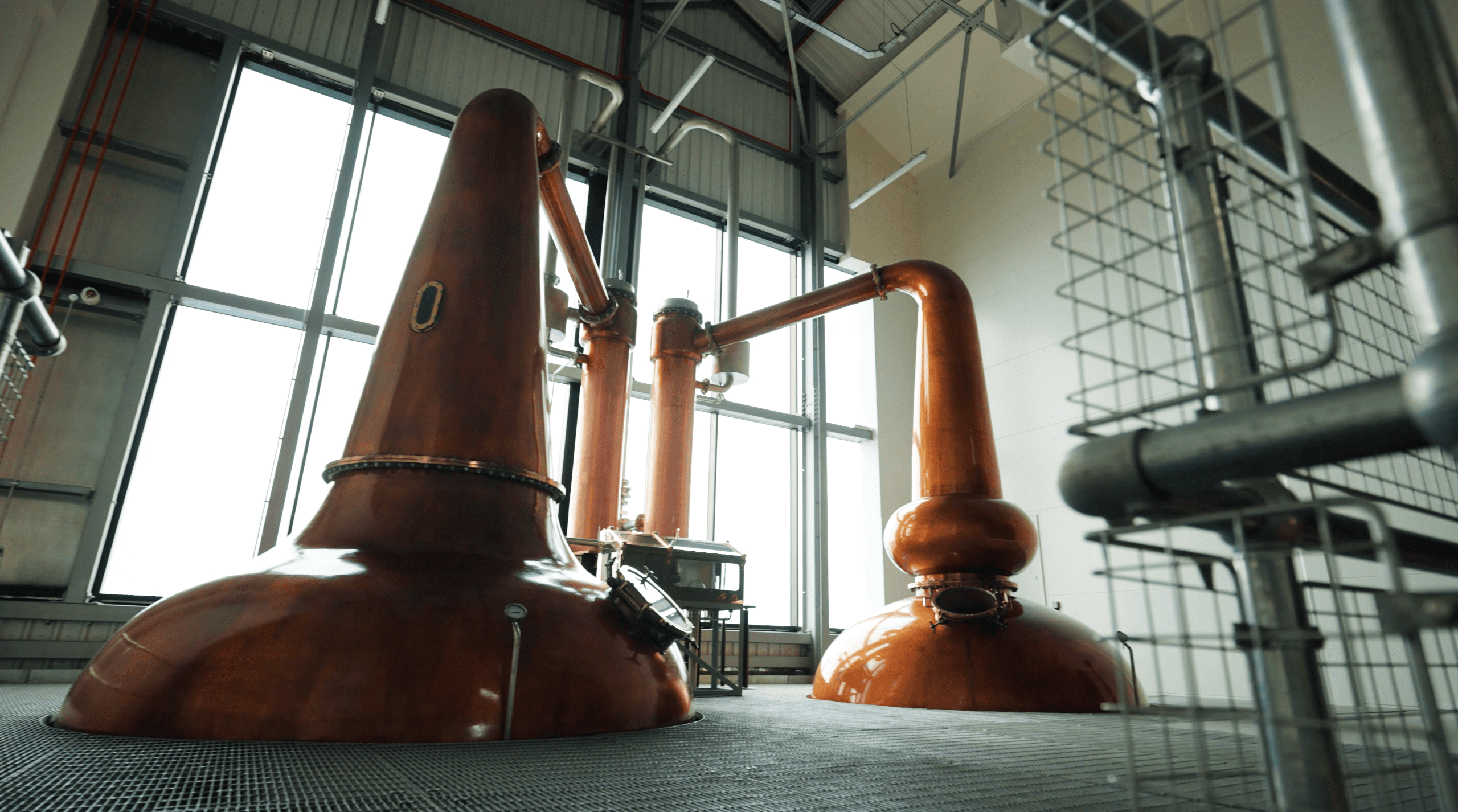 Copper stills in distillery production hall, industrial interior view