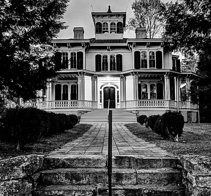 Historic Victorian mansion exterior on landscaped grounds for tours