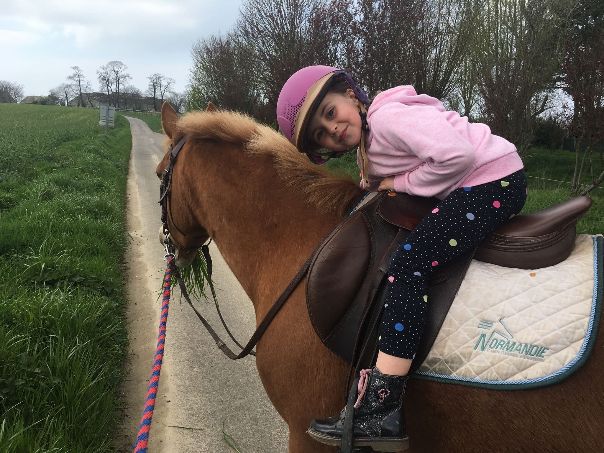 Child horseback riding on rural trail enjoying countryside at Etretat