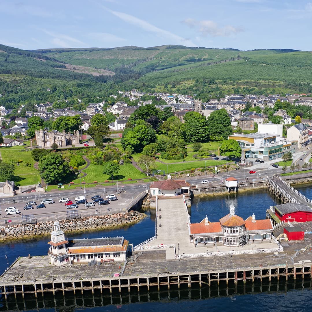 Aerial view of coastal pier, harbour and hillside town