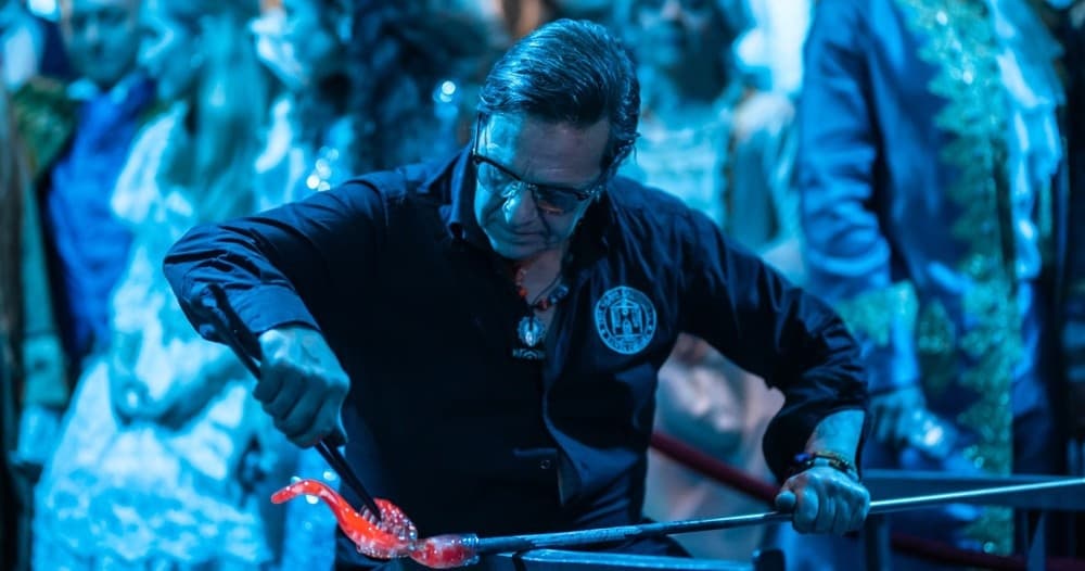 Glassblower shaping molten glass in Murano workshop demo
