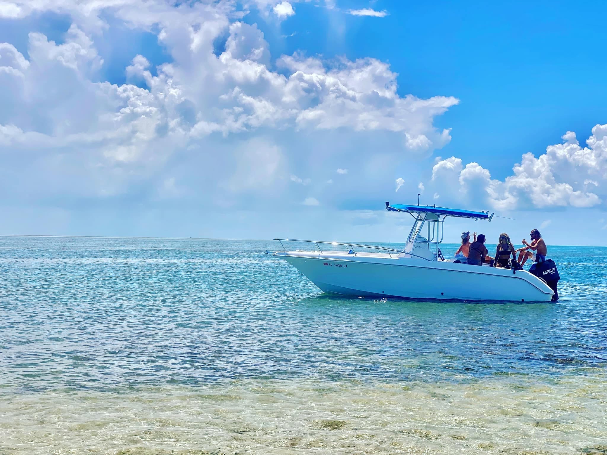 Coastal shallow-water boat tour with passengers in clear sea