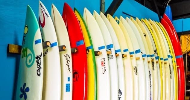 Colorful surfboards racked at seaside surf school shop