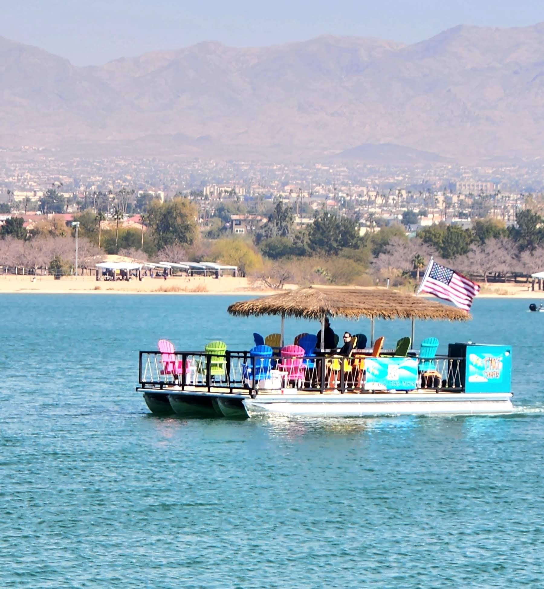 Tiki pontoon boat cruising Lake Havasu with mountain backdrop