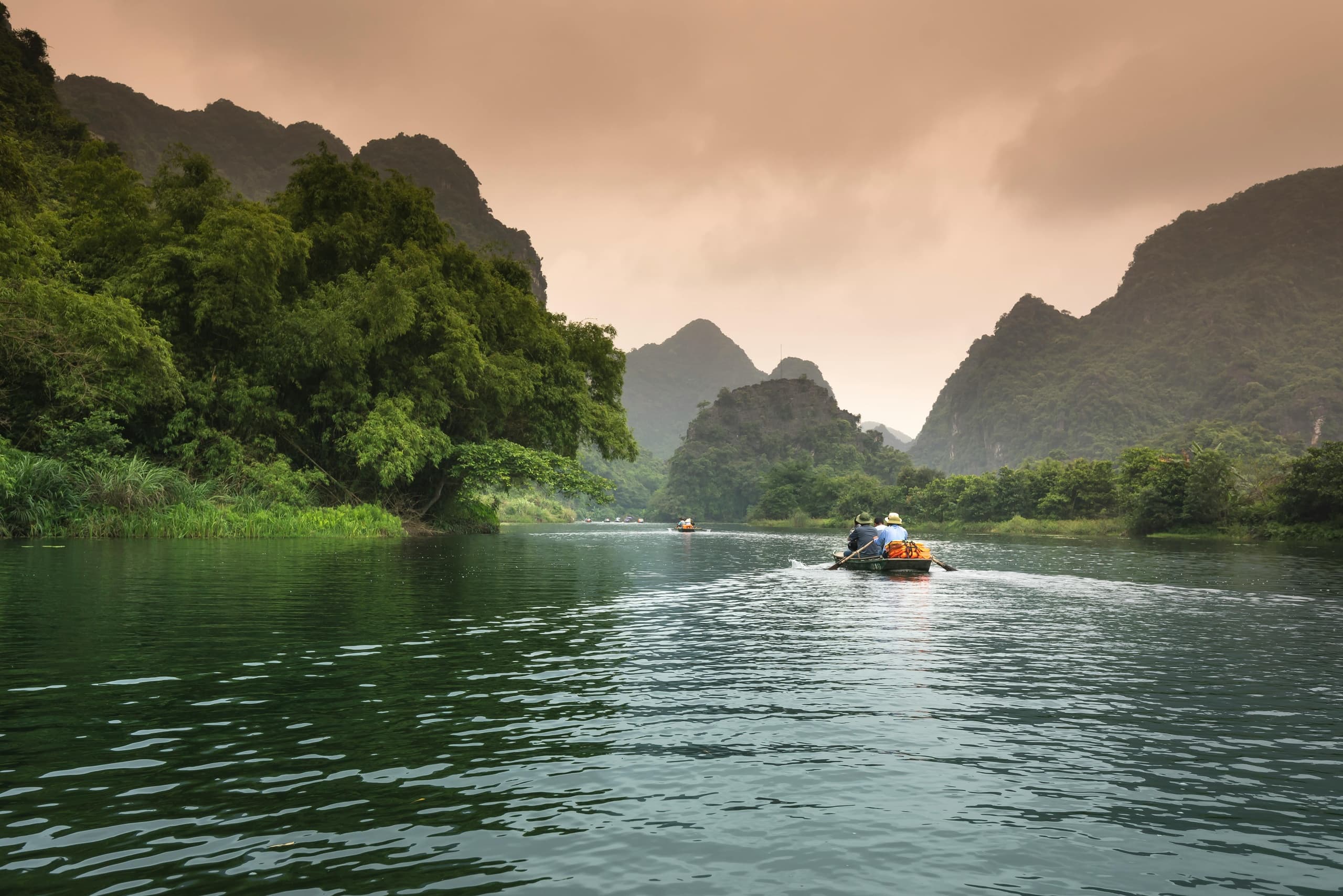 Boat cruising through dramatic karst river gorge, scenic waters