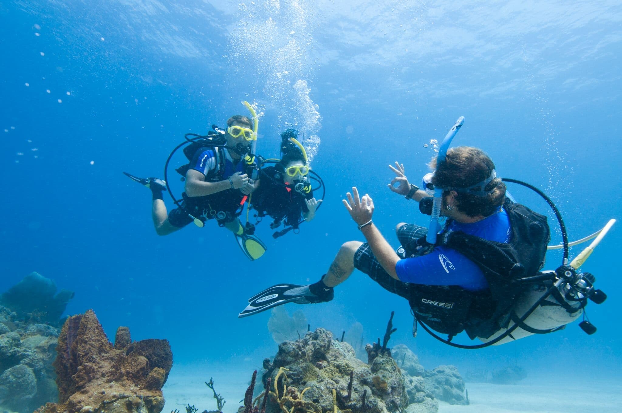 Scuba buddies communicating over tropical reef during dive