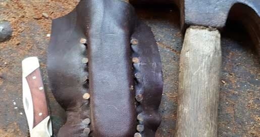 Leather saddle stitching with hammer and tools in workshop