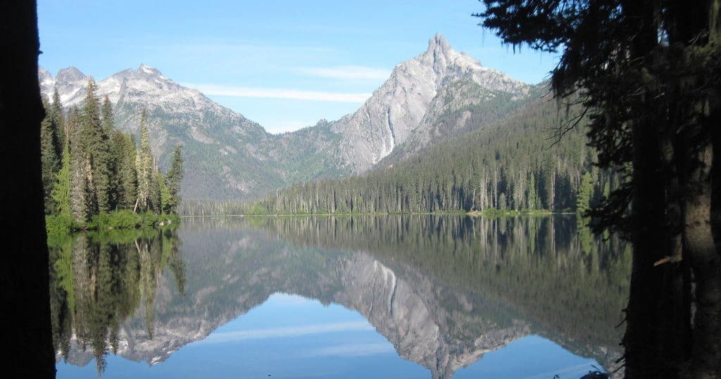 Mountain lake reflection with alpine peaks, serene wilderness view