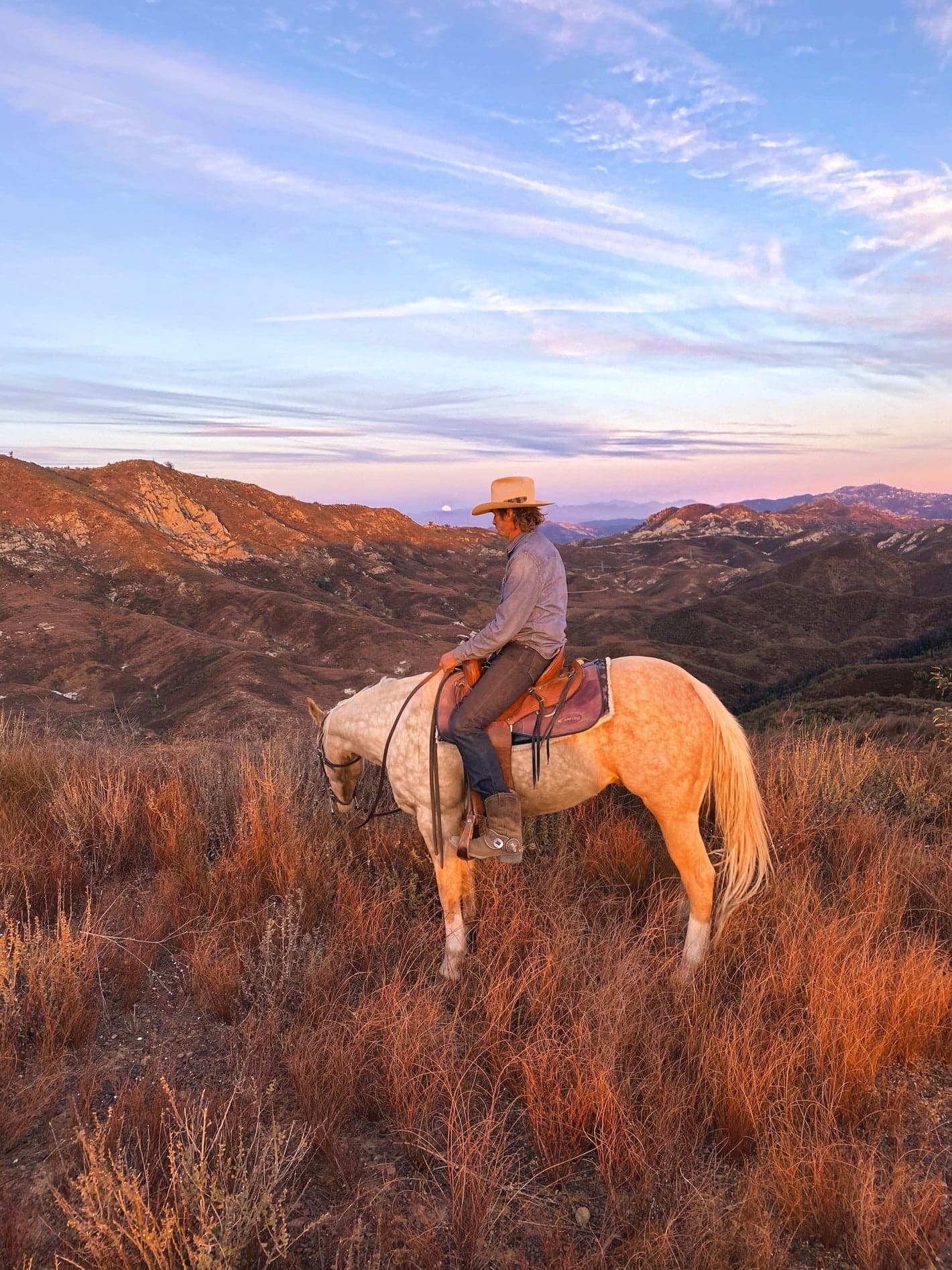 Horseback rider overlooking Malibu hills at sunset