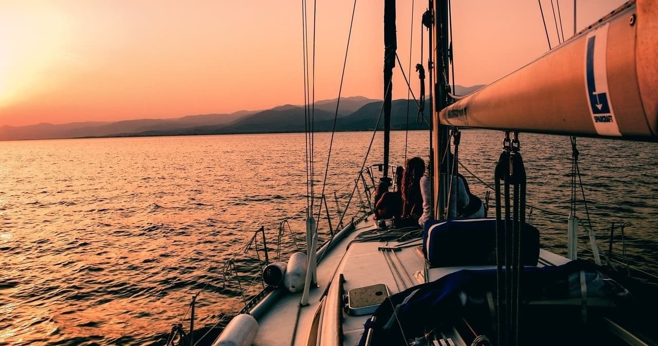 Sailing from deck at sunset, cruising over warm coastal waters