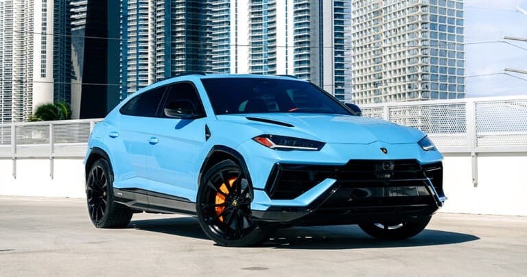 Light blue Lamborghini Urus on rooftop with skyscrapers