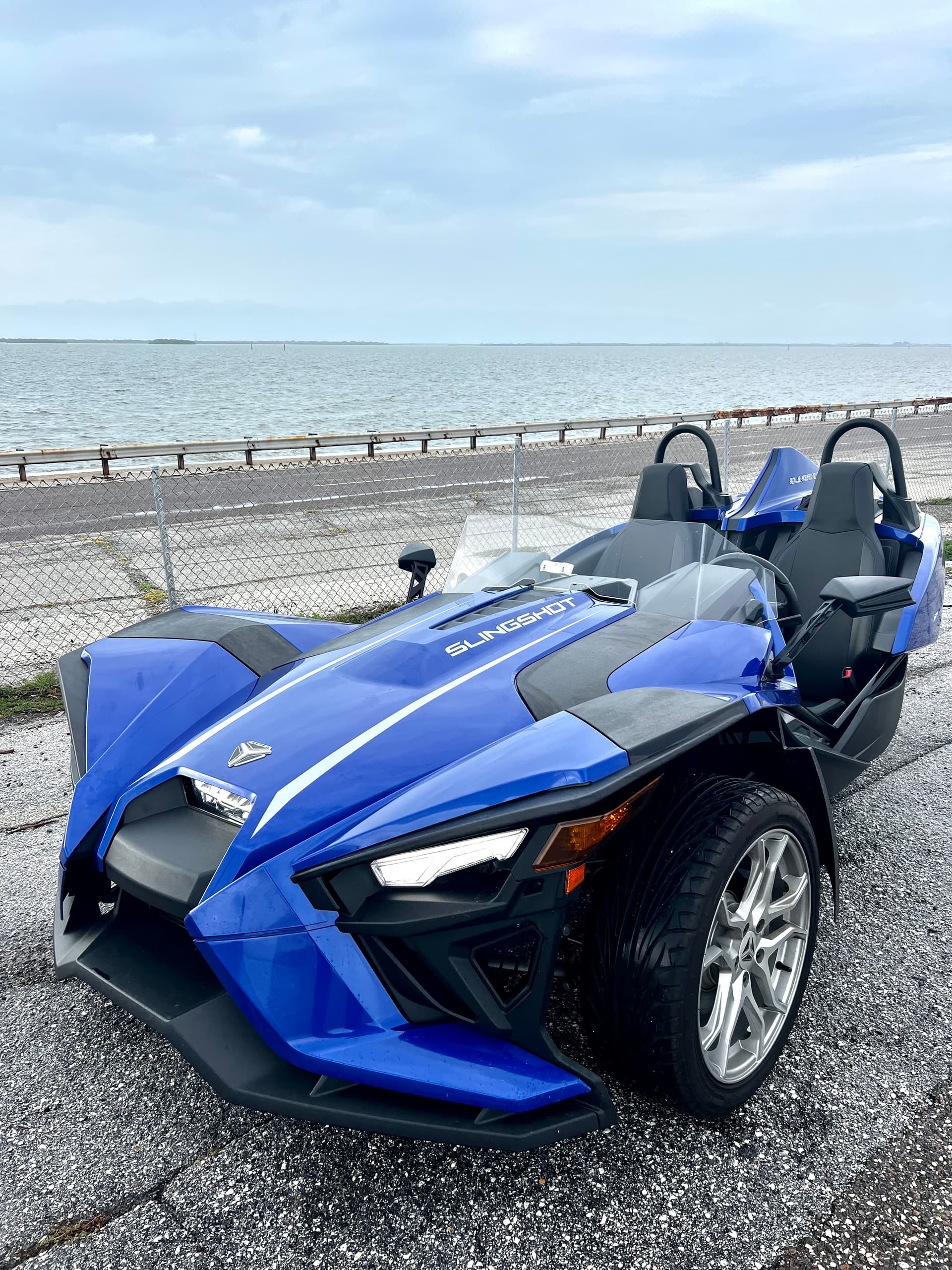 Blue Slingshot parked on waterfront promenade for coastal tour