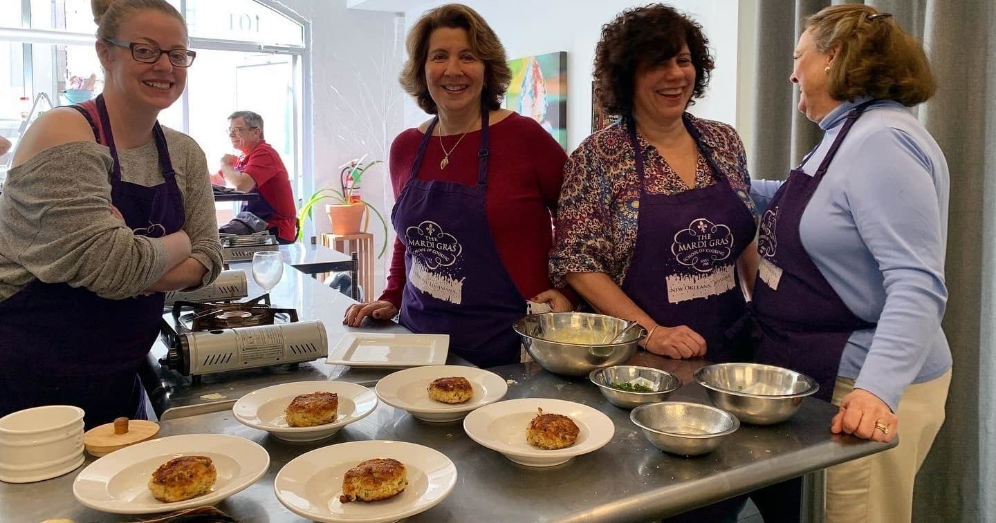 Cooking class instructors preparing Creole dishes in kitchen