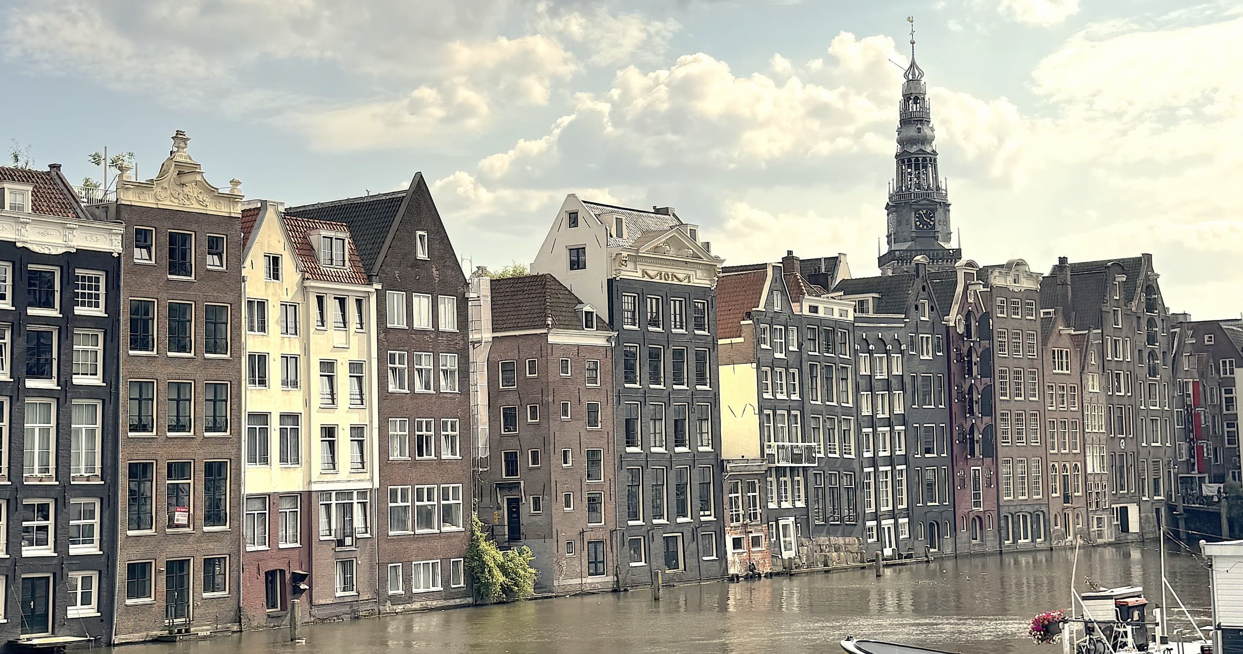 Row of Amsterdam canal houses along waterfront in daylight