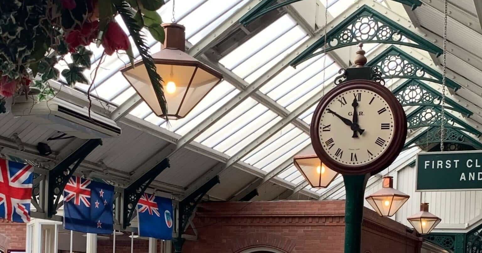 Victorian indoor market clock under glass roof in arcade