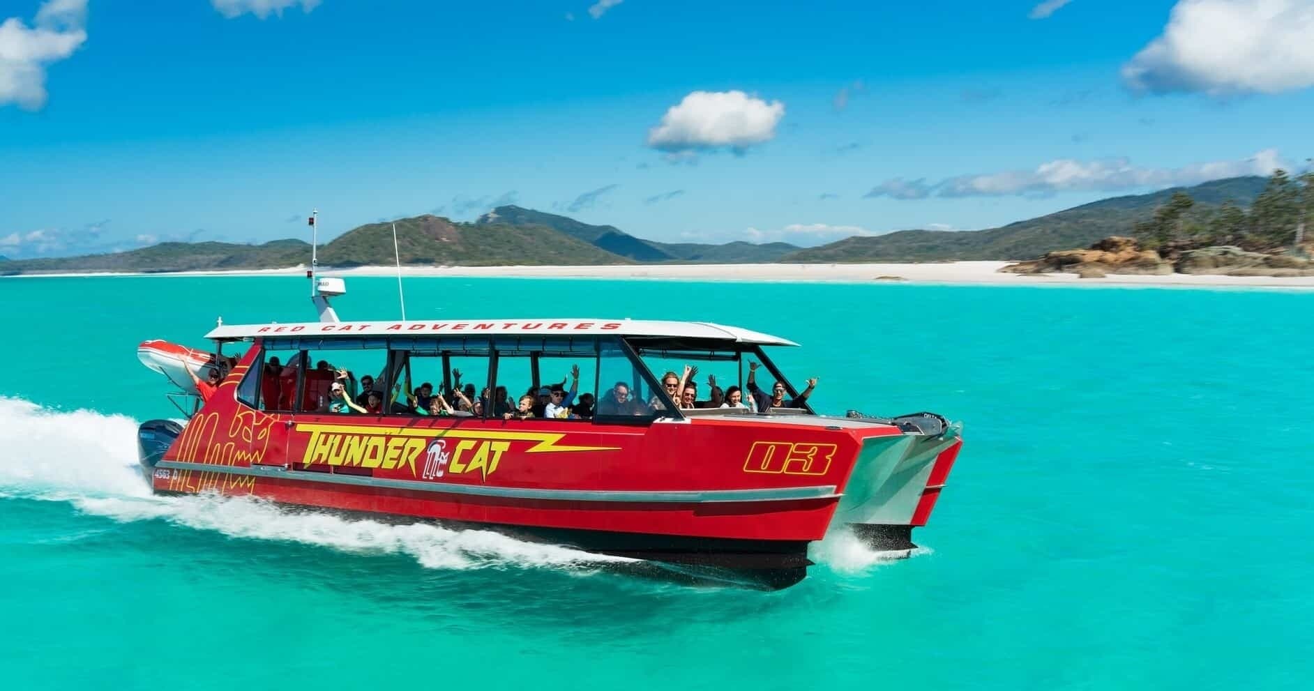 Red speedboat tour on turquoise tropical sea near island