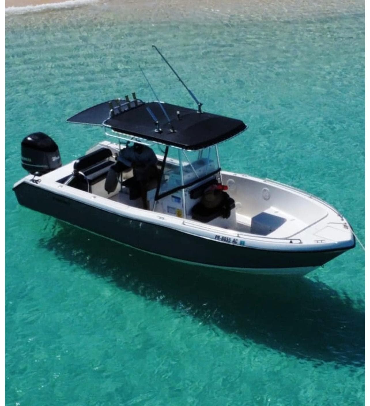 Small motorboat cruising turquoise Caribbean lagoon waters