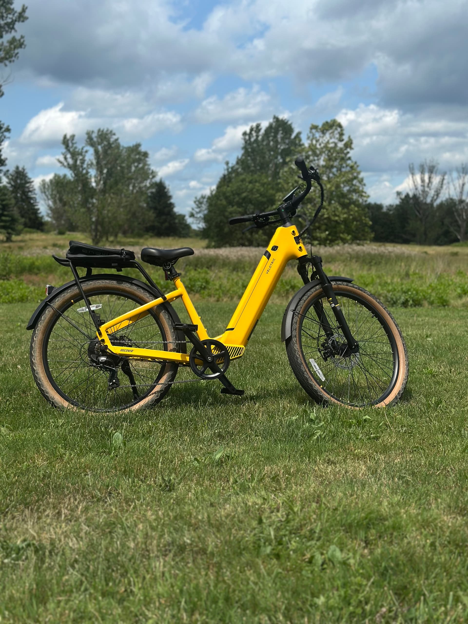 Yellow electric bike parked on grassy countryside trail