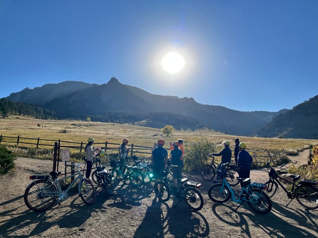 Sunrise group e-bike ride with Flatirons silhouette, riders