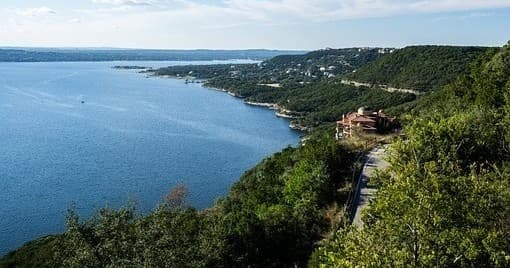 Scenic limestone lakeshore vista with winding road and water