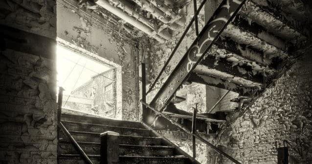 Haunted abandoned stairwell inside derelict building for ghost tour