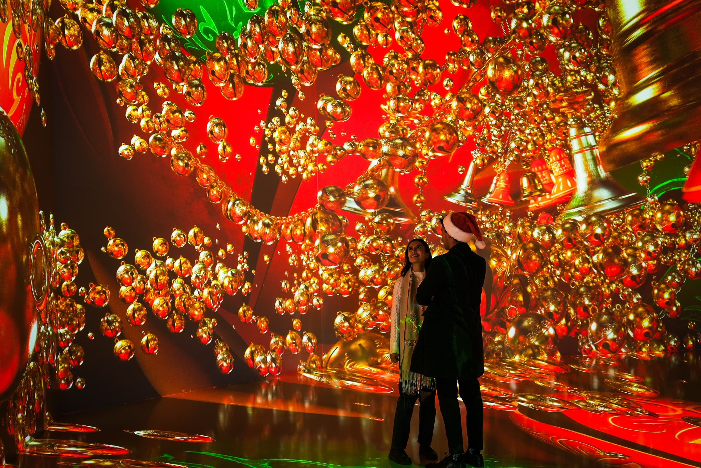 Visitors standing among suspended glowing orbs in digital installation