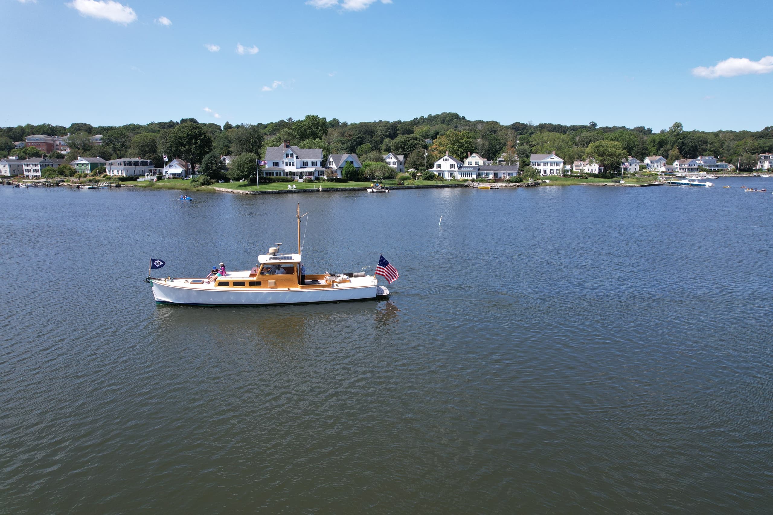 Aerial view of coastal yacht cruising calm harbor waters in Mystic