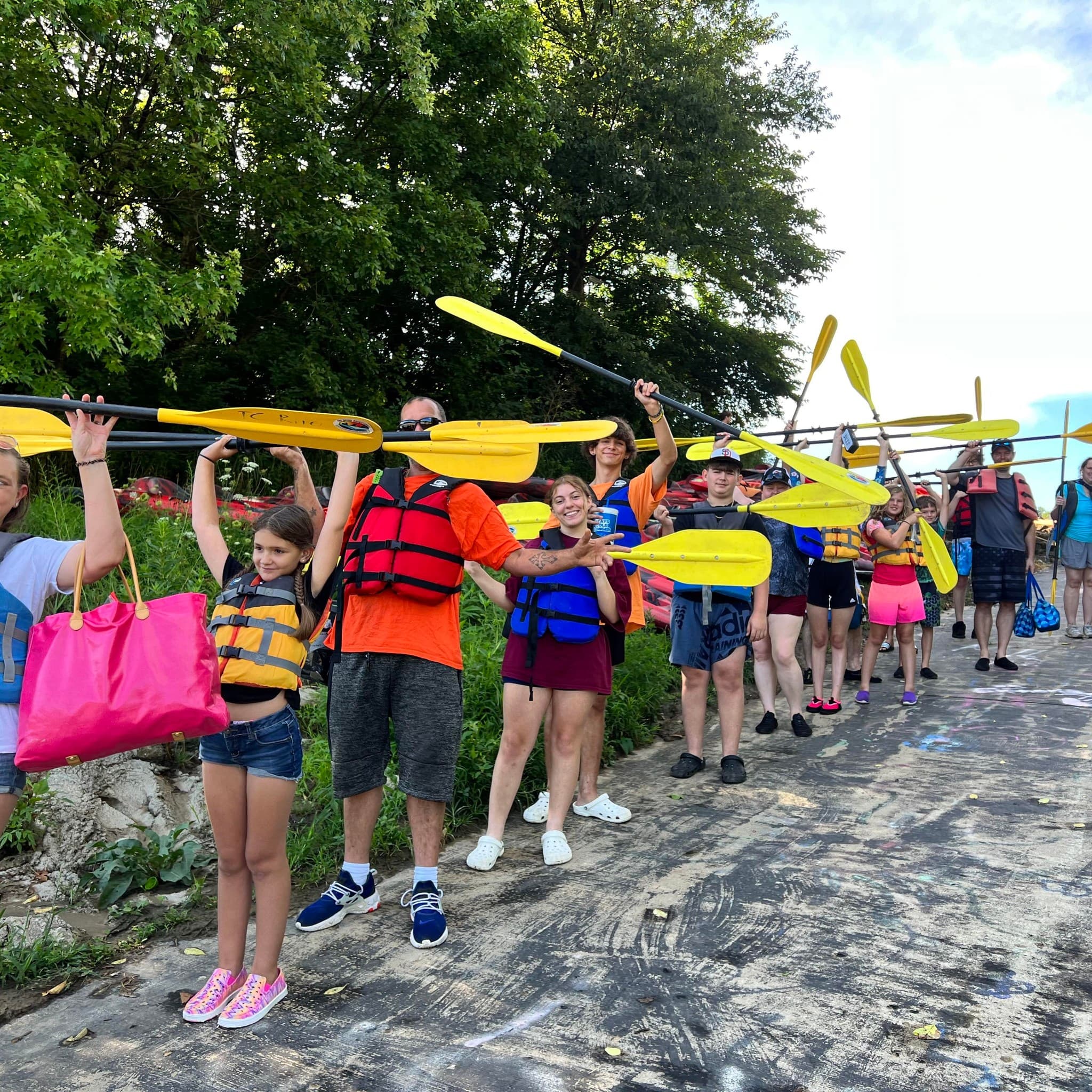 Group of kayakers gearing up with paddles before river launch