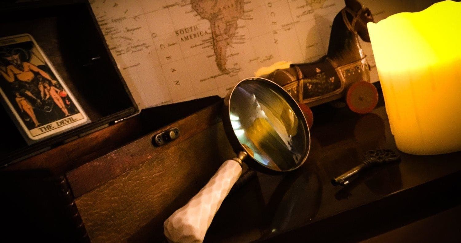Vintage detective desk with magnifying glass and candle clue hunt