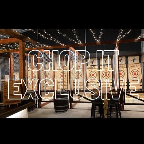 Axe throwing lanes inside Chop It venue with string lights