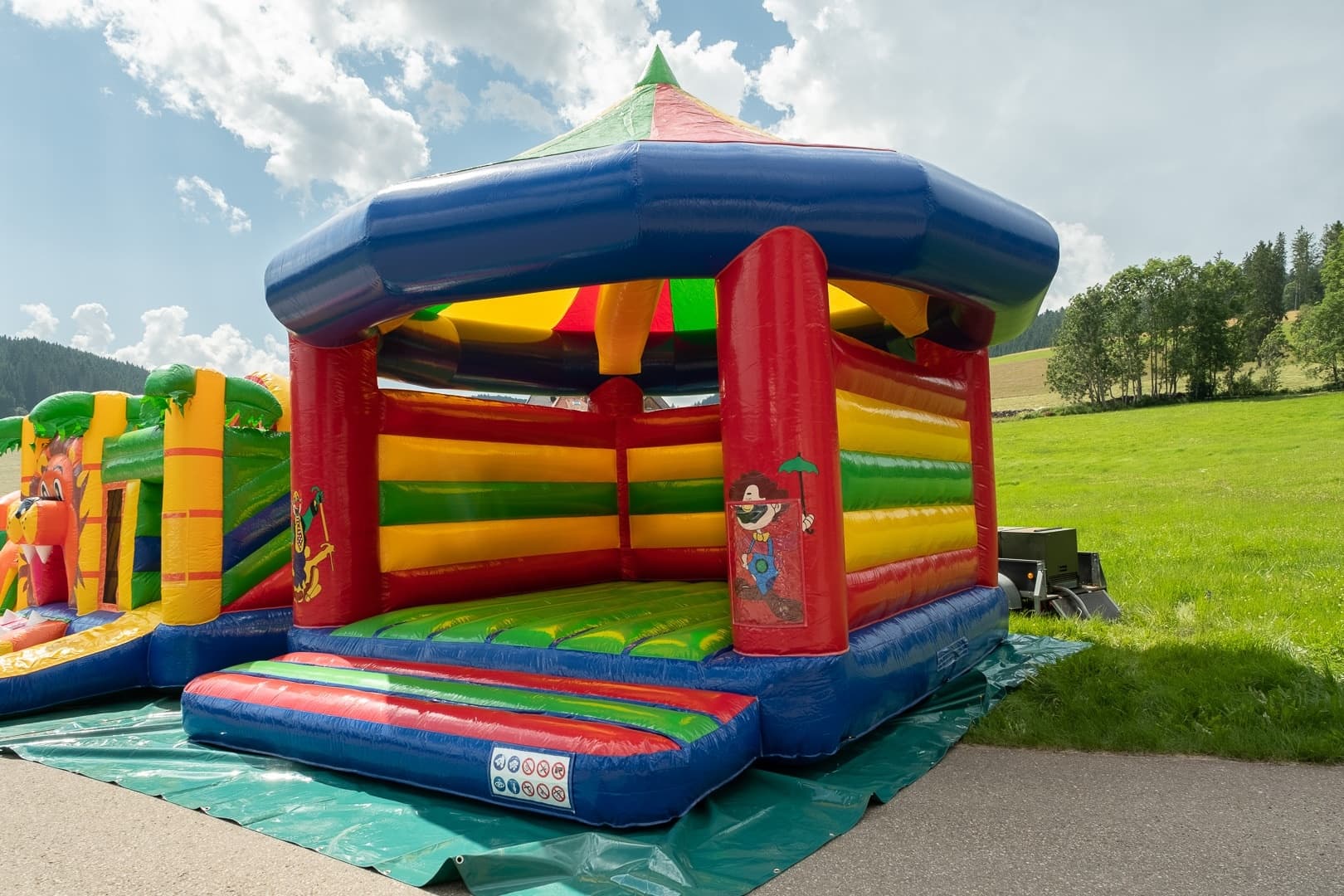Colorful inflatable bouncy castle set on grassy field for kids