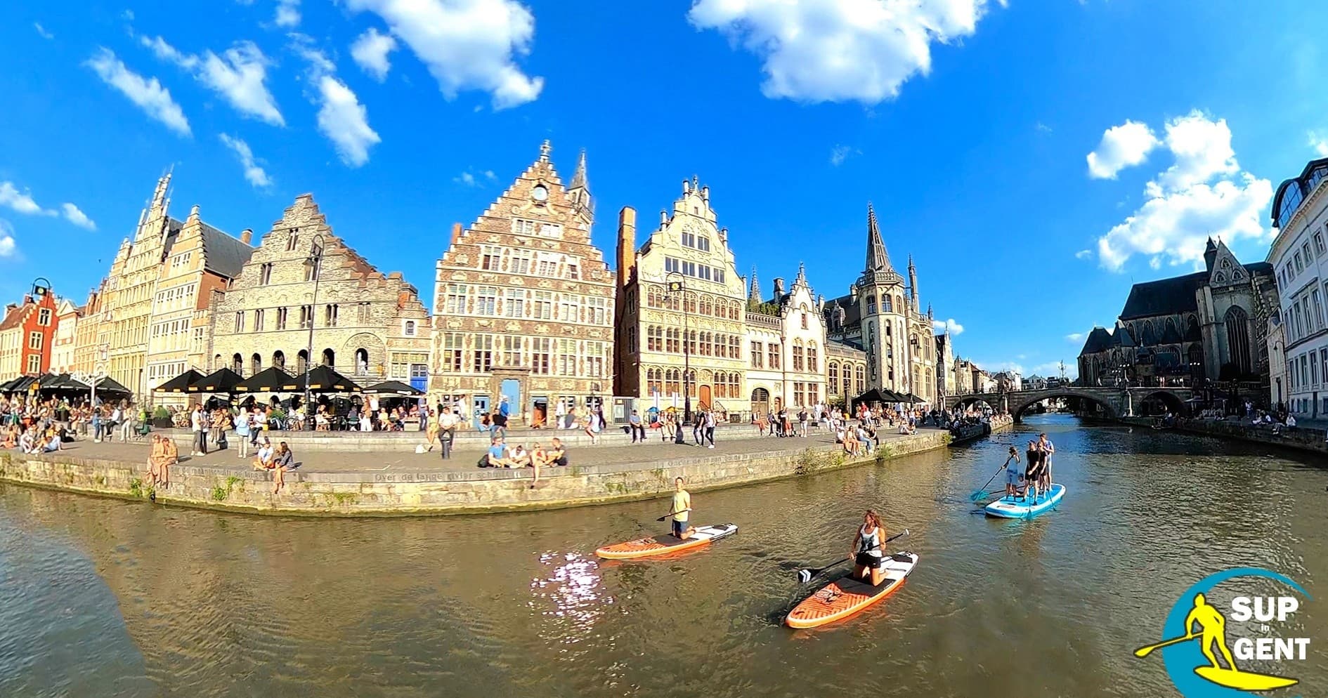 Stand-up paddleboarders on Ghent canal past historic guild houses
