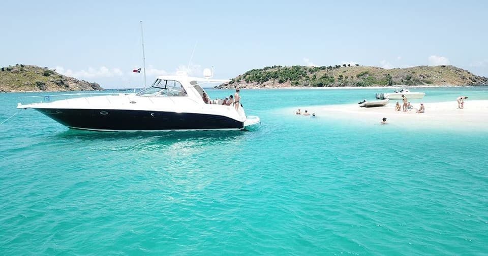 Speedboat cruising turquoise Caribbean water near island beach tour