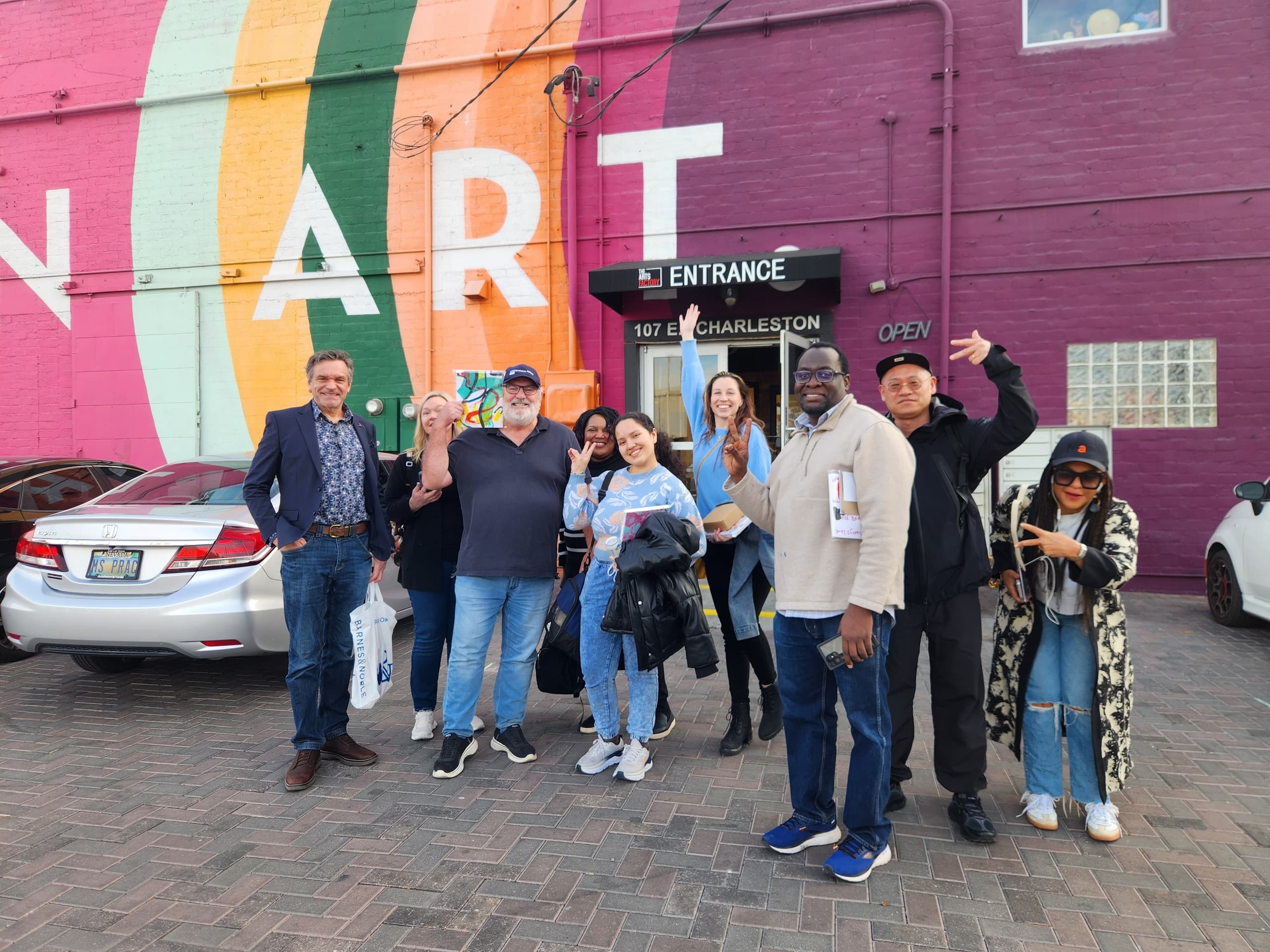 Urban walking tour group posing by colorful mural in Nevada city