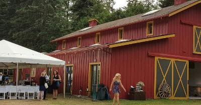 Red barn and outdoor event tents hosting guests at ranch venue
